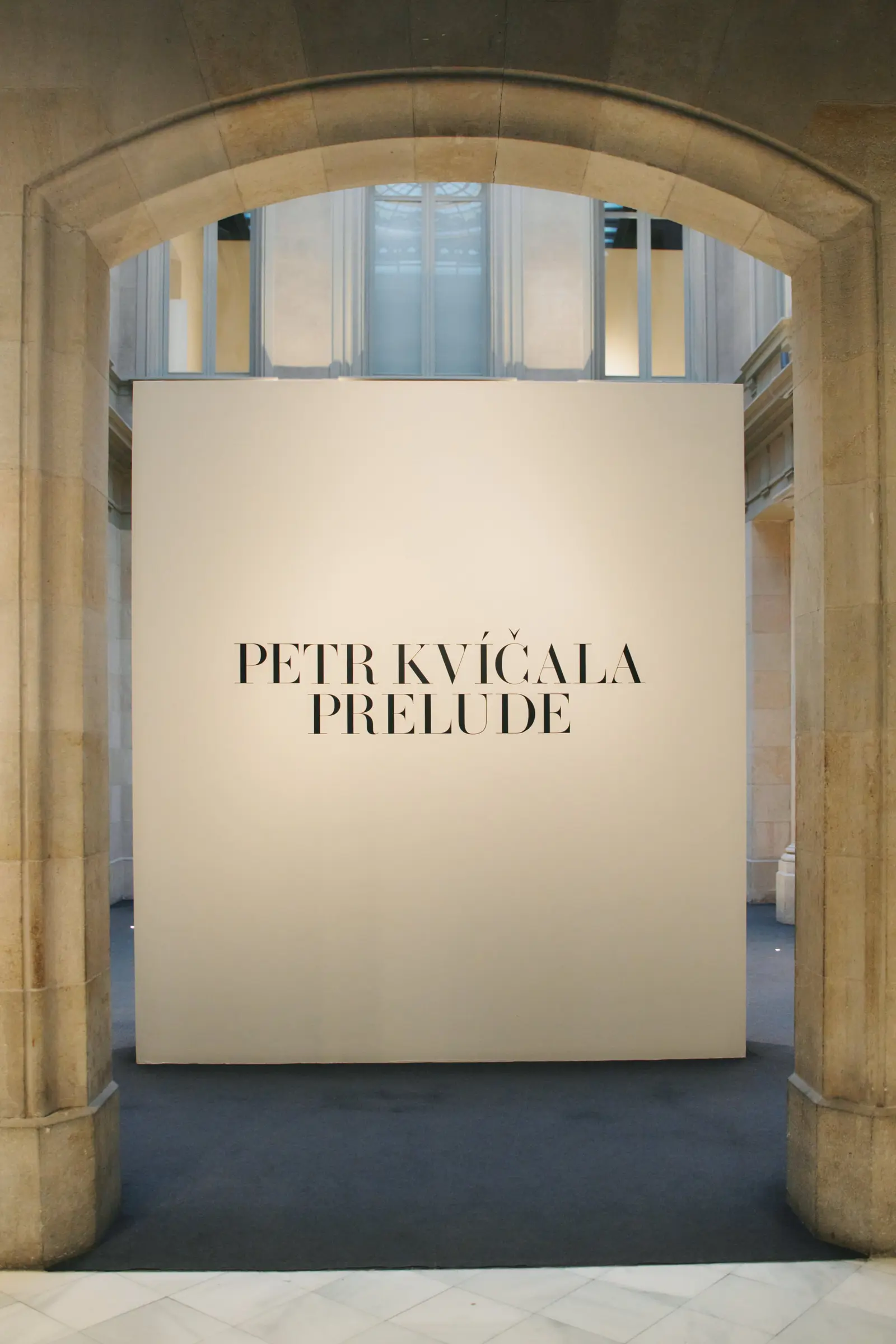 Entrada de l'exposició «Prelude» de Petr Kvíčala, sota un arc de pedra del Palau Martorell